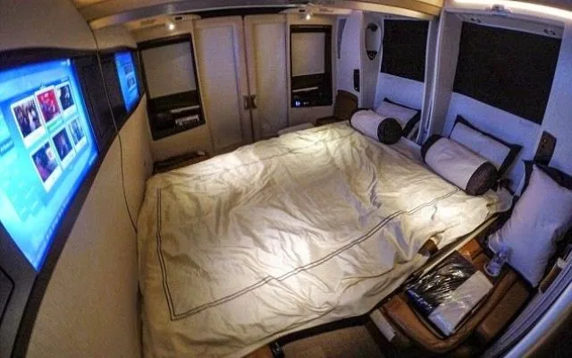 Singapore Airlines A380 Suites Class cabin with separate bed and leather armchair.