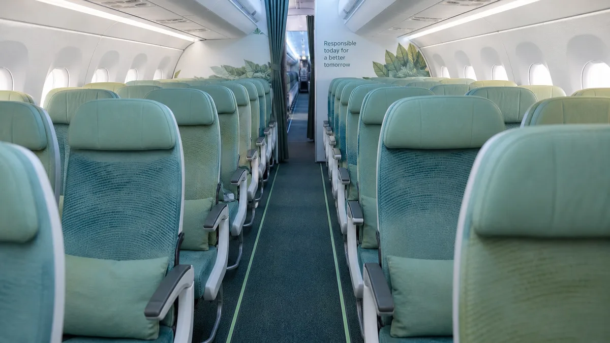 Refreshed aircraft cabin aisle in soft green-blue tones — Emirates fleet refresh and upcycling guide (AI-generated illustration)