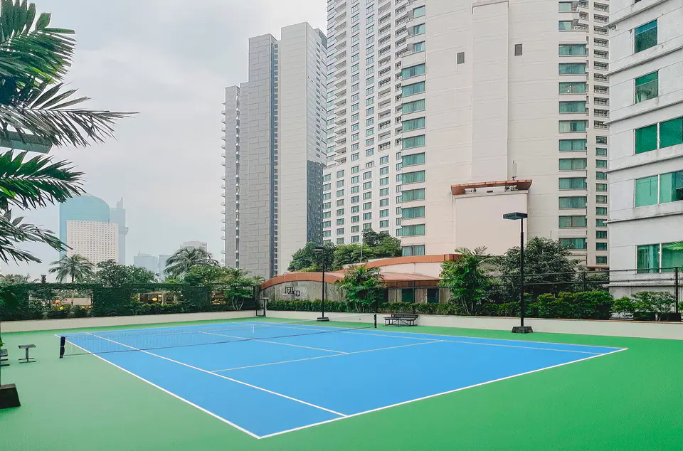 Outdoor tennis courts at AYANA Midplaza Jakarta, ringed by Sudirman high-rises