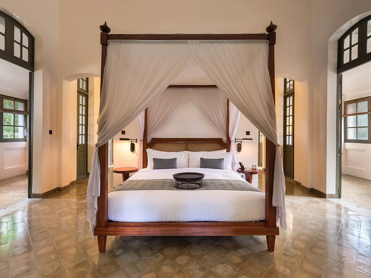 Canopy bed in a luxury hotel suite with warm evening lighting