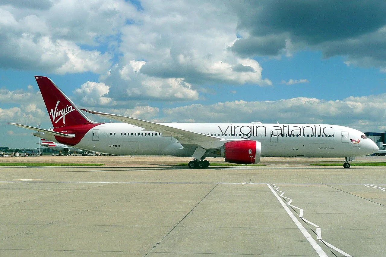 Virgin Atlantic Reward Mastercard with UK passport and Flying Club boarding pass on dark wood surface.